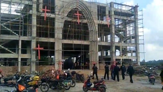 Des agents impliqués dans la démolition forcée entrent dans l’église.