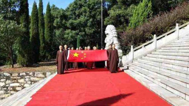 Des moines au temple Wanshan situé dans la ville de Lushan, dans la province du Jiangxi, assistent à une cérémonie de levée du drapeau.