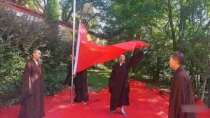 Des moines au temple Wanshan situé dans la ville de Lushan, dans la province du Jiangxi, assistent à une cérémonie de levée du drapeau.