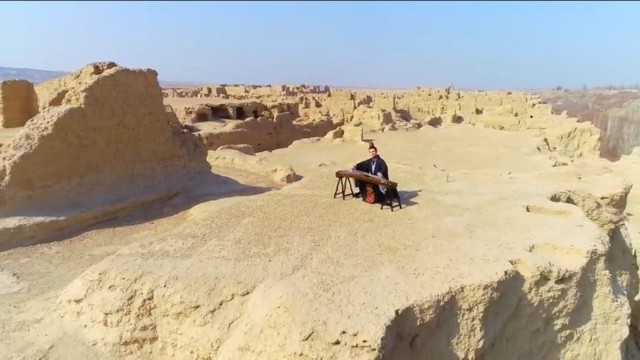 Un musicien chinois han jouant du gu zheng sur l’un des plateaux de l’ancienne citadelle de Jiaohe, dans la ville de Turpan, lors des festivités du Nouvel An chinois chez les Ouïghours.