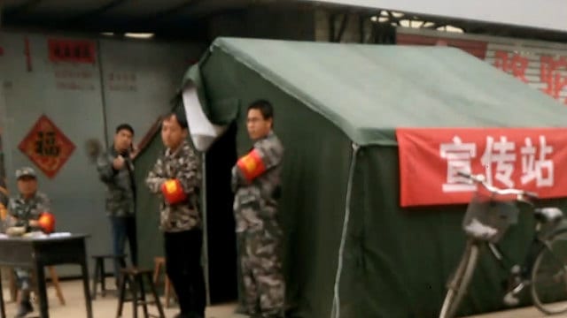 Des agents de police montant la garde à l’extérieur du village.