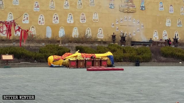 Après avoir été démantelée, la statue de Guanyin ruisselante a été placée sur le côté et recouverte d’un tissu.