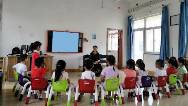 Une enseignante de classe maternelle s’adresse à ses élèves