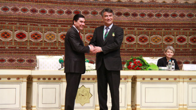 Tashpolat Tiyip en train de recevoir le Prix international Magtymguly des mains du président du Turkmenistan, Gurbanguly Berdimuhamedow (à gauche).